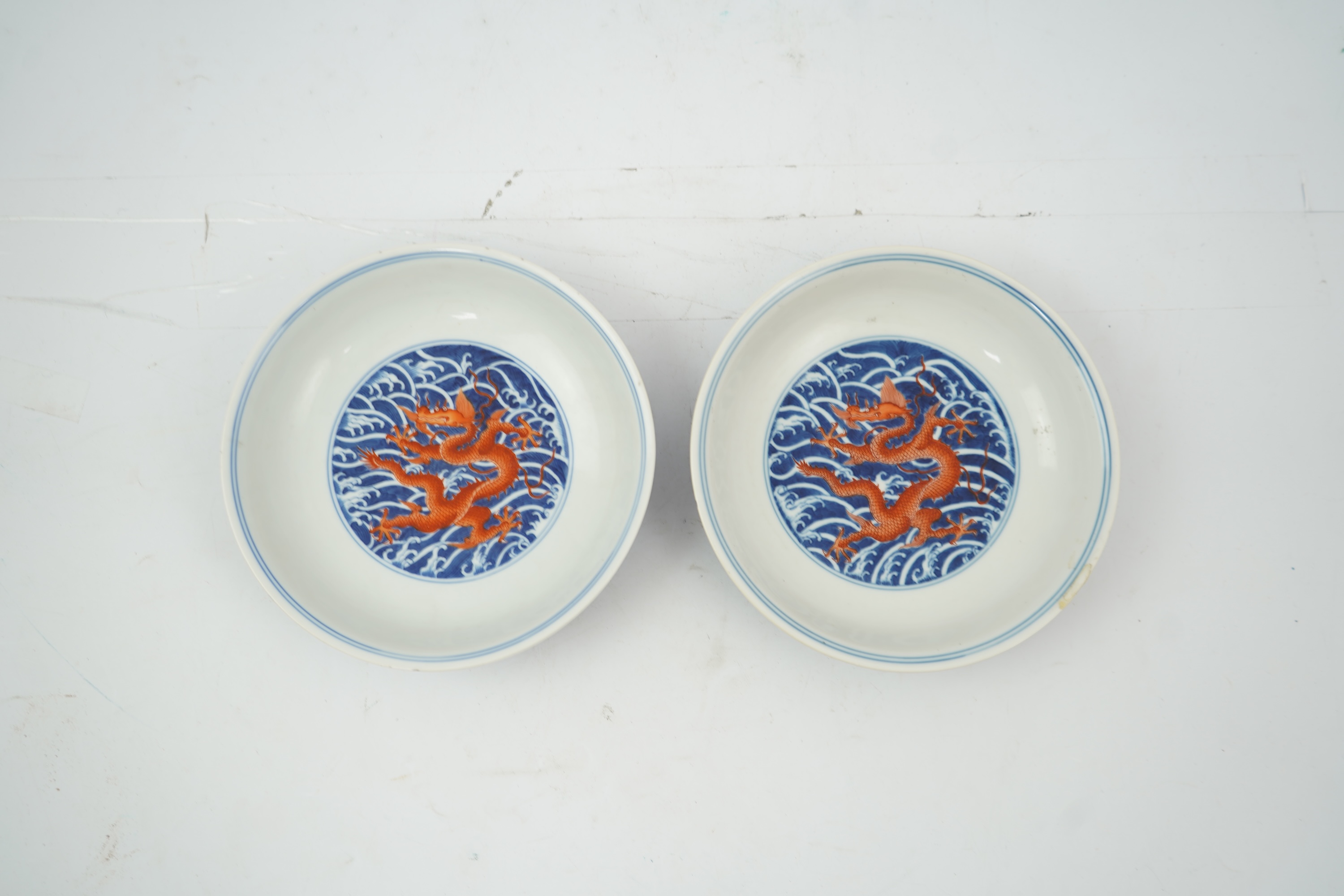 A pair of Chinese iron red and underglaze blue ‘dragon’ dishes, Qianlong seal mark and of the period (1736-95)